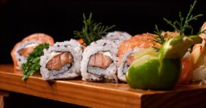 Delicious sushi rolls artfully arranged on a wooden platter, perfect for culinary promotions.